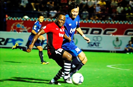 Ludovick Takam, center, shields the ball from a PTT Rayong defender during their Toyota Cup match in Rayong, Saturday, July 2. (Photo/Ariyawat Nuamsawat)